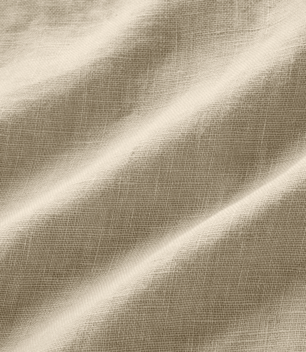 A close-up of draped beige fabric with a fine woven texture and soft folds.