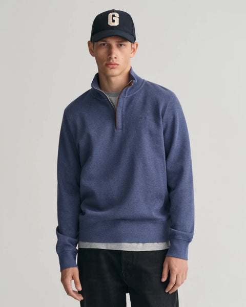 GANT - Sacker Rib Half-Zip Sweatshirt - Dark Jeans-Blue Melange worn by a model, featuring half-zip collar and tonal logo.