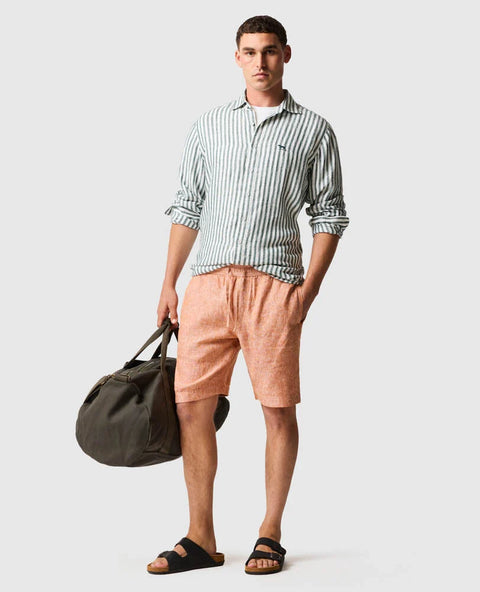 Rodd & Gunn - Seadown Linen Shirt - Stripe - Forest showcased on a model with casual shorts and a duffle bag.