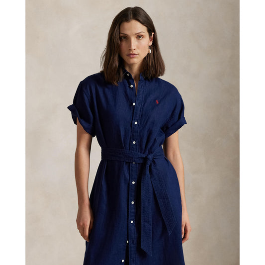 Woman wearing a blue Linen shirt dress, short sleeve, holding a straw bag - Polo Ralph Lauren - Belted Short-Sleeved Linen Shirt Dress - Newport Navy
