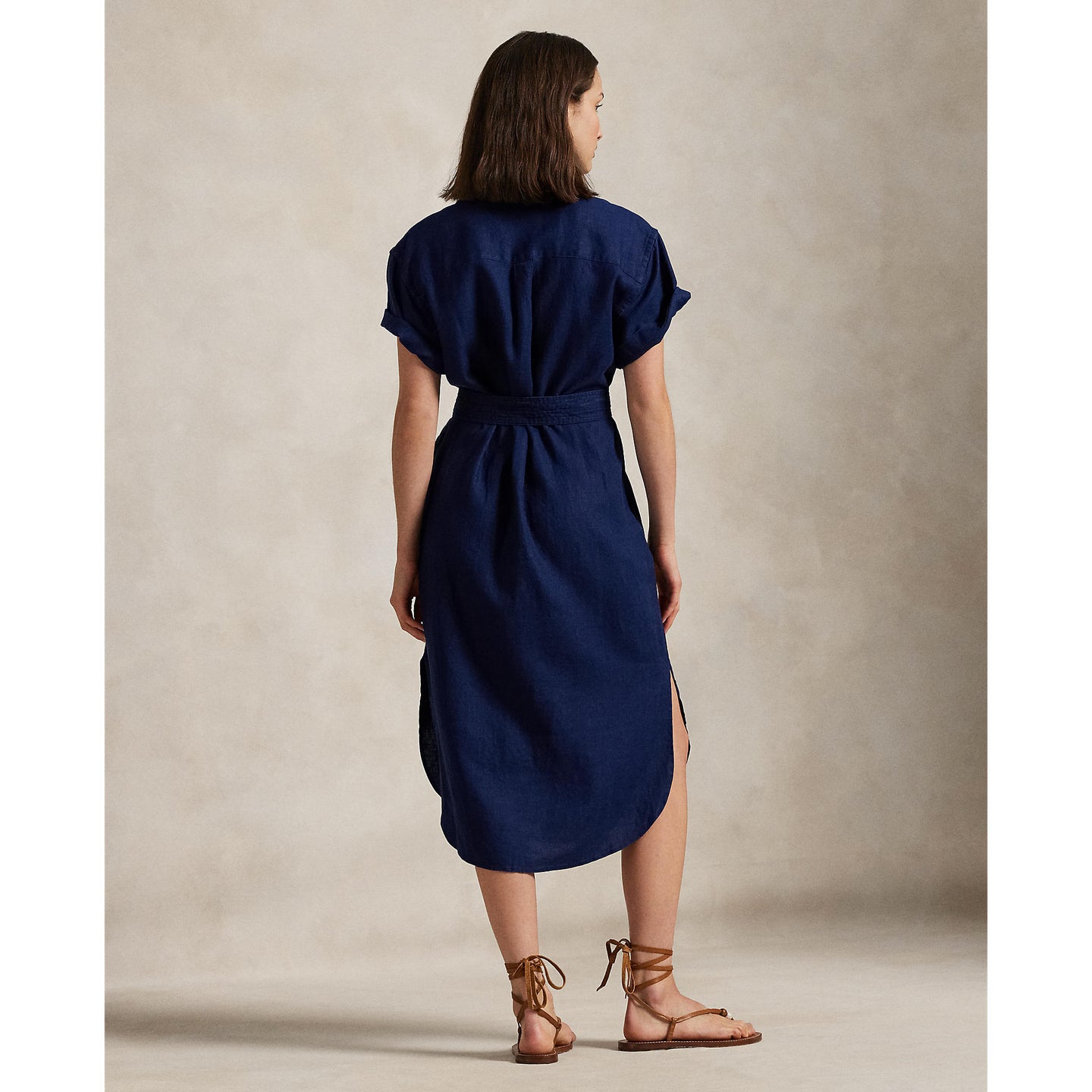Woman wearing a blue Linen shirt dress, short sleeve, holding a straw bag - Polo Ralph Lauren - Belted Short-Sleeved Linen Shirt Dress - Newport Navy