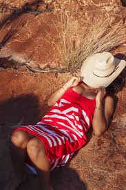 Ringers Western - Striped Towel - Red & White displayed on a person relaxing outdoors in a sun hat.